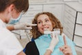 Dentist comparing patient`s teeth shade with samples for bleaching treatment Royalty Free Stock Photo