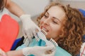 Dentist comparing patient`s teeth shade with samples for bleaching treatment Royalty Free Stock Photo