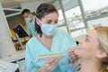 Dentist curing woman patient in dental office