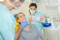 Dentist curing woman patient in dental office