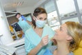 Dentist curing woman patient in dental office