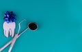 Dentist day tooth and dental instruments on a blue background. Copy space for text.