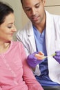 Dentist Demonstrating How To Brush Teeth To Female Patient