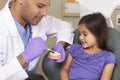 Dentist Demonstrating How To Brush Teeth To Young Female Patient Royalty Free Stock Photo