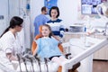 Dentist in dental office telling little girl the treatment will not be painfull Royalty Free Stock Photo