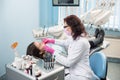 Dentist with dental tools - mirror and probe checking up patient teeth at dental clinic office. Medicine, dentistry Royalty Free Stock Photo