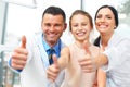 Dentist doctor, assistant and little girl all smiling at camera