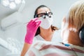 Dentist doctor in magnifying glasses with Dental explorer tool. Young Female ready for teeth surgery. Dental clinic patient Royalty Free Stock Photo