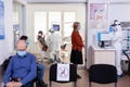 Dentist doctor in ppe suit consulting patient in dental clinic