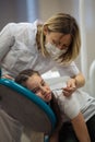 Dentist doing teeth checkup of little girl looking afraid