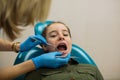 Dentist doing teeth checkup of little girl patient in medical clinic