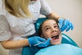 Dentist doing teeth checkup of teen girl in a dental chair at medical room