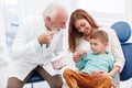 Dentist educating child patient about teeth brushing techniques