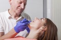 Dentist examines gums and teeth of his female patient