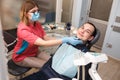 A dentist examines his patient's teeth. Action in the dental clinic