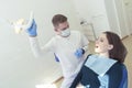 dentist examines the patient's mouth at a clinic appointment