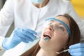 Dentist examines woman oral cavity in office closeup