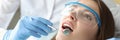 Dentist examines woman oral cavity in office closeup