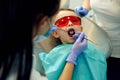 Dentist examining little boy`s teeth in clinic. A little boy opening mouth at a teeth treatment Royalty Free Stock Photo