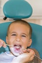 Dentist examining little boy& x27;s teeth in clinic. Close up of boy having his teeth examined by a dentist. A child at the dental Royalty Free Stock Photo