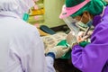 Dentist examining a patients teeth in the chair and bright light at the dental clinic