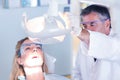 Dentist examining a patients teeth in chair under bright light Royalty Free Stock Photo