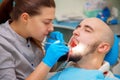 Dentist examining a patients teeth in the dentists chair under b Royalty Free Stock Photo