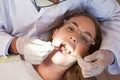 Dentist examining a patients teeth in the dentists chair under bright light Royalty Free Stock Photo