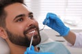 Dentist examining young man`s teeth in clinic, closeup Royalty Free Stock Photo