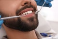 Dentist examining young man`s teeth in clinic, closeup Royalty Free Stock Photo