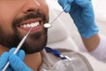 Dentist examining young man`s teeth in clinic, closeup Royalty Free Stock Photo
