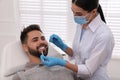 Dentist examining young man`s teeth in modern clinic Royalty Free Stock Photo