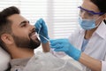 Dentist examining young man`s teeth in clinic Royalty Free Stock Photo