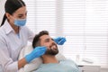 Dentist examining young man`s teeth in modern clinic Royalty Free Stock Photo