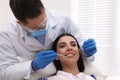 Dentist examining young woman`s teeth in modern clinic Royalty Free Stock Photo