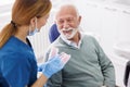 Dentist explaining procedure to patient on plastic jaw model