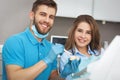 Dentist explaining to female patient how to brush her teeth. Royalty Free Stock Photo