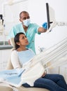 Dentist explaining treatment to female patient in dental clinic Royalty Free Stock Photo