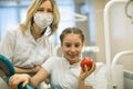 Dentist female gives apple for smiling teenage girl