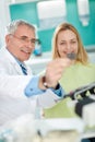 Dentist with female patient look at dental snapshot