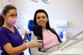 Dentist female showing her patient`s new teeth through the mirror in the dental cabinet. Royalty Free Stock Photo