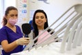 Dentist female showing her patient`s new teeth through the mirror in the dental cabinet. Royalty Free Stock Photo