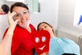 Dentist female showing her patient`s new teeth through the mirror in the dental cabinet. Patient is satisfied Royalty Free Stock Photo