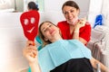 Dentist female showing her patient`s new teeth through the mirror in the dental cabinet. Patient is satisfied Royalty Free Stock Photo