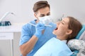 Dentist filling patient's teeth in clinic