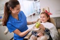 Dentist giving green apple to patient