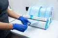 Dentist hands in blue gloves holding dentist tools using sterilizing box