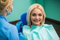 Dentist and happy smiling blonde woman. Work of stomatologist with patient. Make your smile perfect.