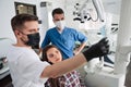 Dentist and his assistant explain details of the x ray image to the patient Royalty Free Stock Photo