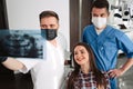 Dentist and his assistant explain details of the x ray image to the patient Royalty Free Stock Photo